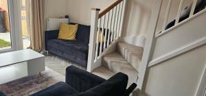 a living room with a staircase with a couch and a chair at Private room in a 2-bedroom house in Dinnington
