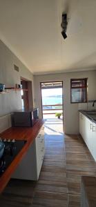 a kitchen with white cabinets and a wooden floor at Apex Ocean and Mountainview in Gordonʼs Bay