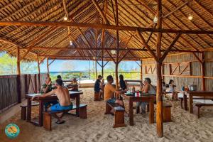 a group of people sitting at tables in a hut at Ny Fano Kite Lodge in Ivovona