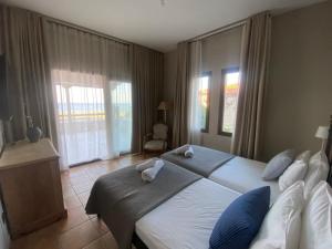a bedroom with a large bed with blue and white pillows at Villa Agali in Agia Anna