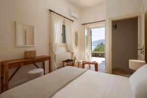 a bedroom with a bed and a balcony at Horizon Beach House by Andros Villas Collection in Andros
