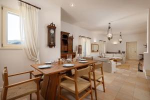 a living room with a wooden table and chairs at Horizon Beach House by Andros Villas Collection in Andros