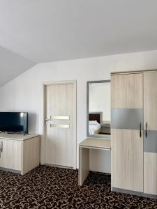 a room with a bed and a desk and a mirror at ILSA Properties in Craiova