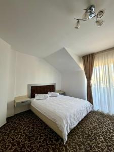 a bedroom with a white bed and a window at ILSA Properties in Craiova