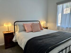 a bedroom with a bed with pillows and two lamps at The Blue Nest, Clare in Clare