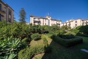 a garden with hedges and bushes in front of a building at Mi casa tu casa - Guest House in Catania