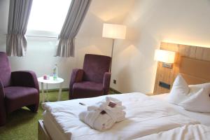 a hotel room with a bed and two chairs at Hotel Tannhof in Feldberg