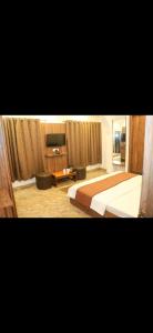 a hotel room with two beds and a television at Hotel Meghdoot in Pachmarhī