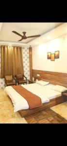a bedroom with a large bed and a ceiling fan at Hotel Meghdoot in Pachmarhī