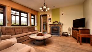 a living room with a couch and a tv at Vakantie & wellness Erezee in Érezée