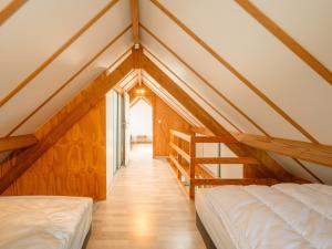 ein Dachgeschosszimmer mit zwei Betten und einer Treppe in der Unterkunft Zeepark Haerendycke in Wenduine