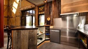 a kitchen with stainless steel appliances and wooden walls at Vakantie & wellness Erezee in Érezée