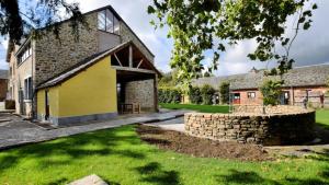 an external view of a building with a stone wall at Vakantie & wellness Erezee in Érezée