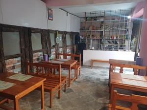a restaurant with wooden tables and benches in a room at The Explorer's Den in Munsyari