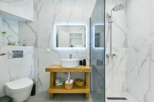 a bathroom with a sink and a toilet and a shower at Blue Residences in Paralia Vrachou +68 photos