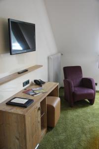 a room with a desk and a chair and a television at Hotel Tannhof in Feldberg