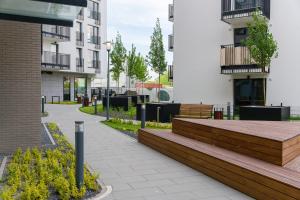 a building with a wooden bench in a courtyard at Riverside Apartments by KRAMM in Poznań