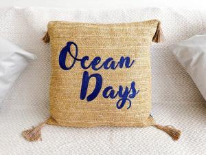 a woven pillow with the words ocean days on it at Seaside Serenity at Ocean Days in Brading
