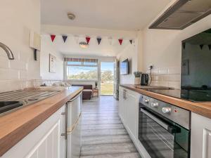 a kitchen with white cabinets and a counter top at Seaside Serenity at Ocean Days in Brading