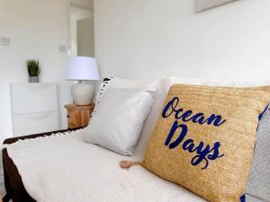 a couch with a pillow that says ocean days at Seaside Serenity at Ocean Days in Brading