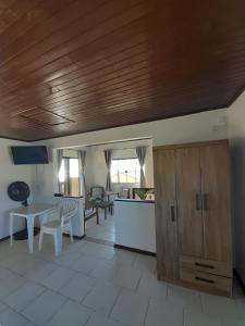 a kitchen and living room with a wooden ceiling at Studio Duplex Praia do Porto in Imbituba