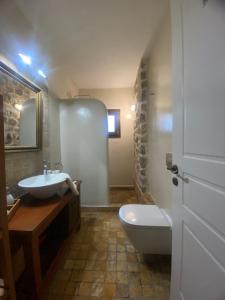 a bathroom with a sink and a toilet and a tub at Villa Agali. in Agia Anna
