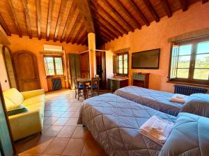 a bedroom with two beds and a flat screen tv at Bed & Breakfast Casale Gregoriano in San Gimignano