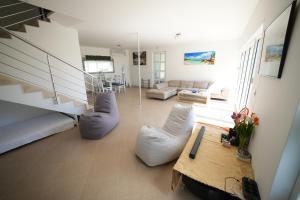a living room with white furniture and a staircase at Vila Brca in Brca