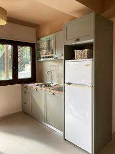 a kitchen with a white refrigerator and a sink at Filippos Resort by the Sea in Vourvourou +49 photos