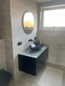 a bathroom with a sink and a mirror at Ferienhaus Heimatgefühl in Würselen