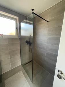 a shower with a glass door in a bathroom at Ferienhaus Heimatgefühl in Würselen