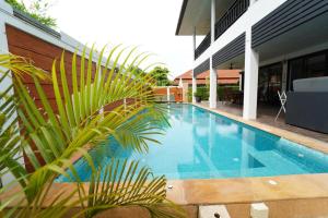 a large blue swimming pool next to a building at Malee Beach C8 in Phra Ae beach