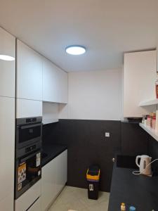 a kitchen with white cabinets and a black counter top at Apartman Mirjana in Mlini +5 photos