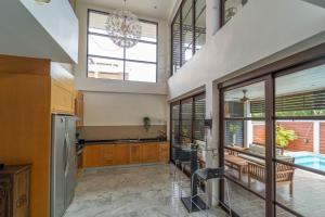 a large kitchen with a table and a refrigerator at Malee Beach C8 in Phra Ae beach