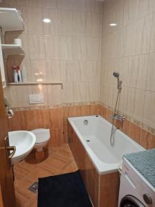 a bathroom with a tub and a toilet and a sink at Apartman Mirjana in Mlini
