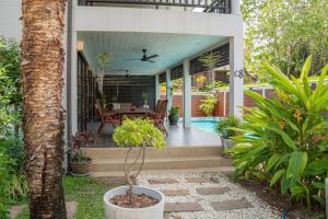 a porch of a house with a table and chairs at Malee Beach C8 in Phra Ae beach