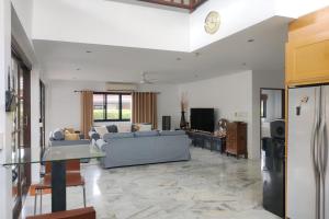 a living room with a blue couch and a kitchen at Malee Beach C8 in Phra Ae beach