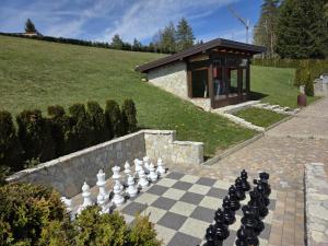 a chess board on a stone path in front of a building at Plitvice Palace Rooms - Adults Only in Grabovac