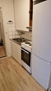 a kitchen with a stove and a sink and a refrigerator at Economy stay - Self Check-in in Vaasa