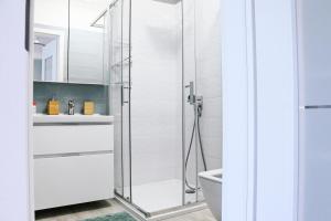 a white bathroom with a glass shower stall at Azure Bay Residence in Balatonfenyves +22 photos