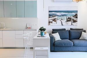 a kitchen and living room with a blue couch at Azure Bay Residence in Balatonfenyves