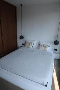 a bedroom with two white beds and two lights at Yalikavak Manzarali Villa in Bodrum City