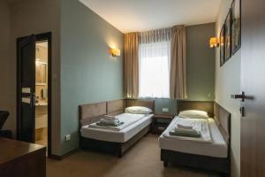 a room with two beds and a window at Leszczynowy Dworek in Gdańsk