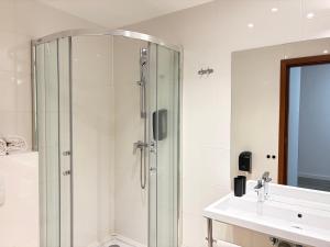 ein Badezimmer mit Dusche und Waschbecken in der Unterkunft LIVINN Tremonia Group - Dortmund Centrum in Dortmund + 31 Fotos