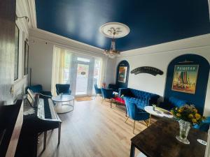 a living room with blue chairs and a blue ceiling at The Great Western B&B in Paignton