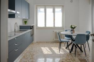 a kitchen with blue cabinets and a table with chairs at Dimora Francesco in Domodossola