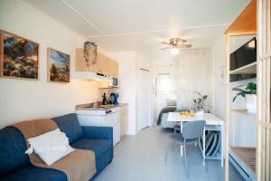 a living room with a blue couch and a kitchen at Navigateur Ste-Luce in Sainte-Luce-sur-Mer