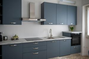 a kitchen with blue cabinets and a sink at Dimora Francesco in Domodossola