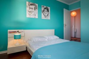 um quarto com uma cama e uma parede azul em Minho Terrace em Caminha