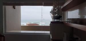 a kitchen with a window with a view of the ocean at CUTTY SARK in Langstrand